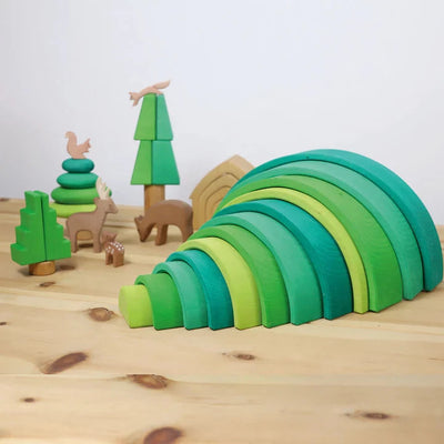 Photo of a green colored large Grimm's rainbow with some woodland animals on a wooden surface.