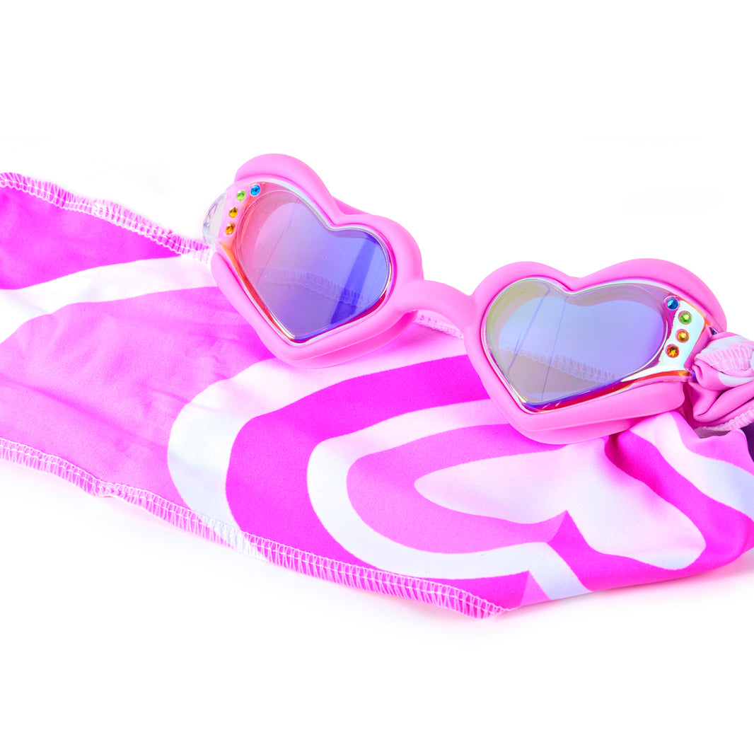 Pink and white striped swimsuit with heart-shaped sunglasses on a white background