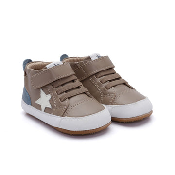 A pair of toddler's mid-top sneakers in taupe brown, featuring faux leather panels, hook-and-loop straps, a white star on the side, a white rubber toe cap, and a light blue heel tab.