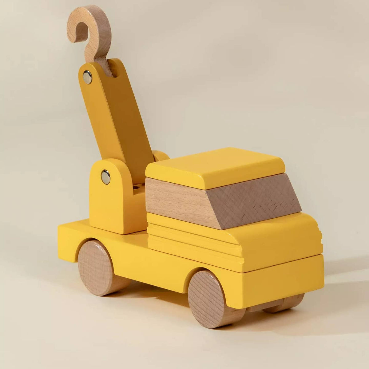 Yellow toy truck with wooden elements on a beige background