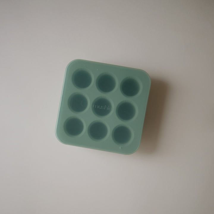 Green silicone ice cube tray on a light gray background