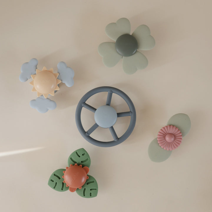 Set of colorful baby teething toys on a light beige background