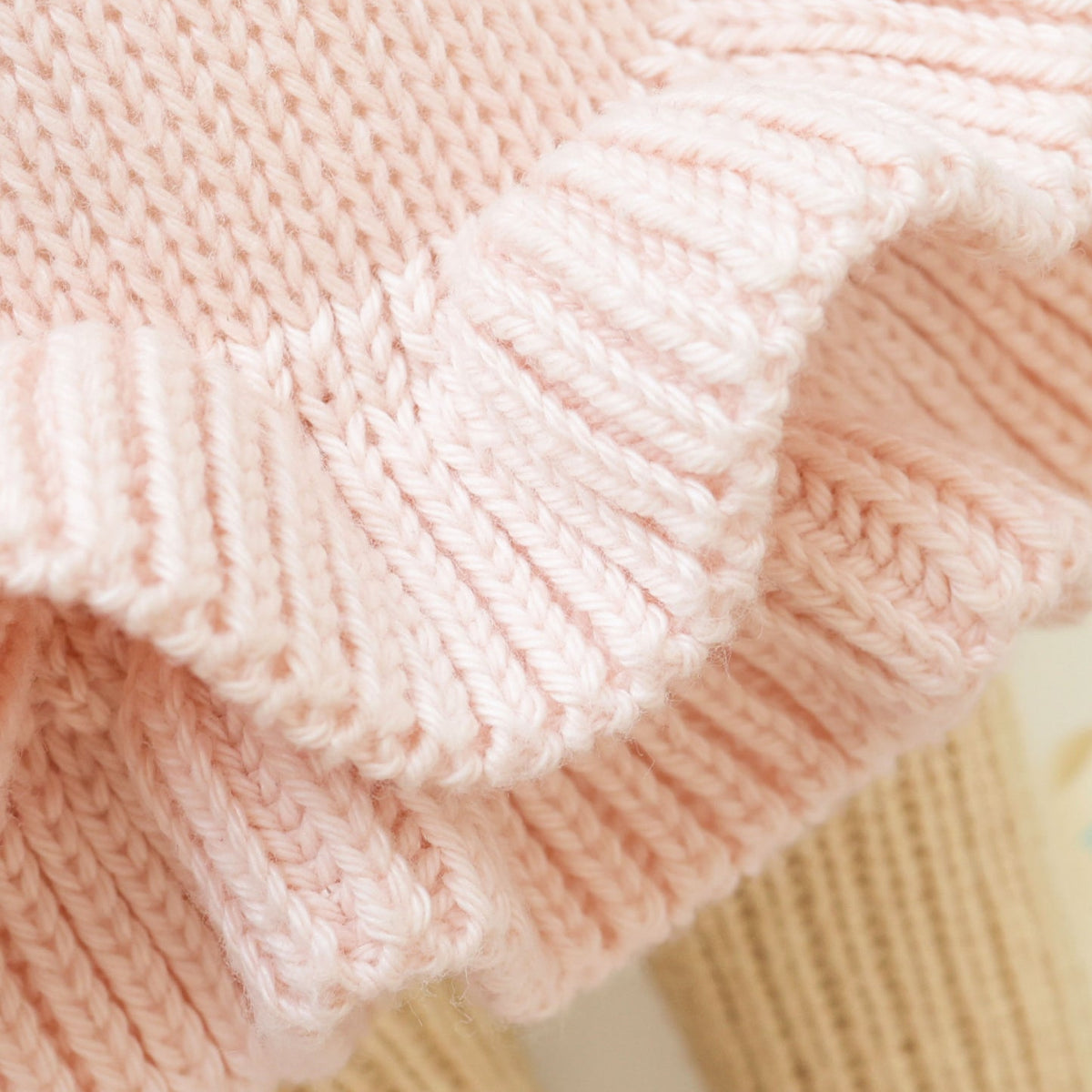 Close-up of pink knitted fabric with a textured pattern