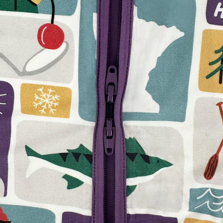 Close-up of a colorful fabric with a zipper running vertically through it, featuring various abstract shapes and patterns.