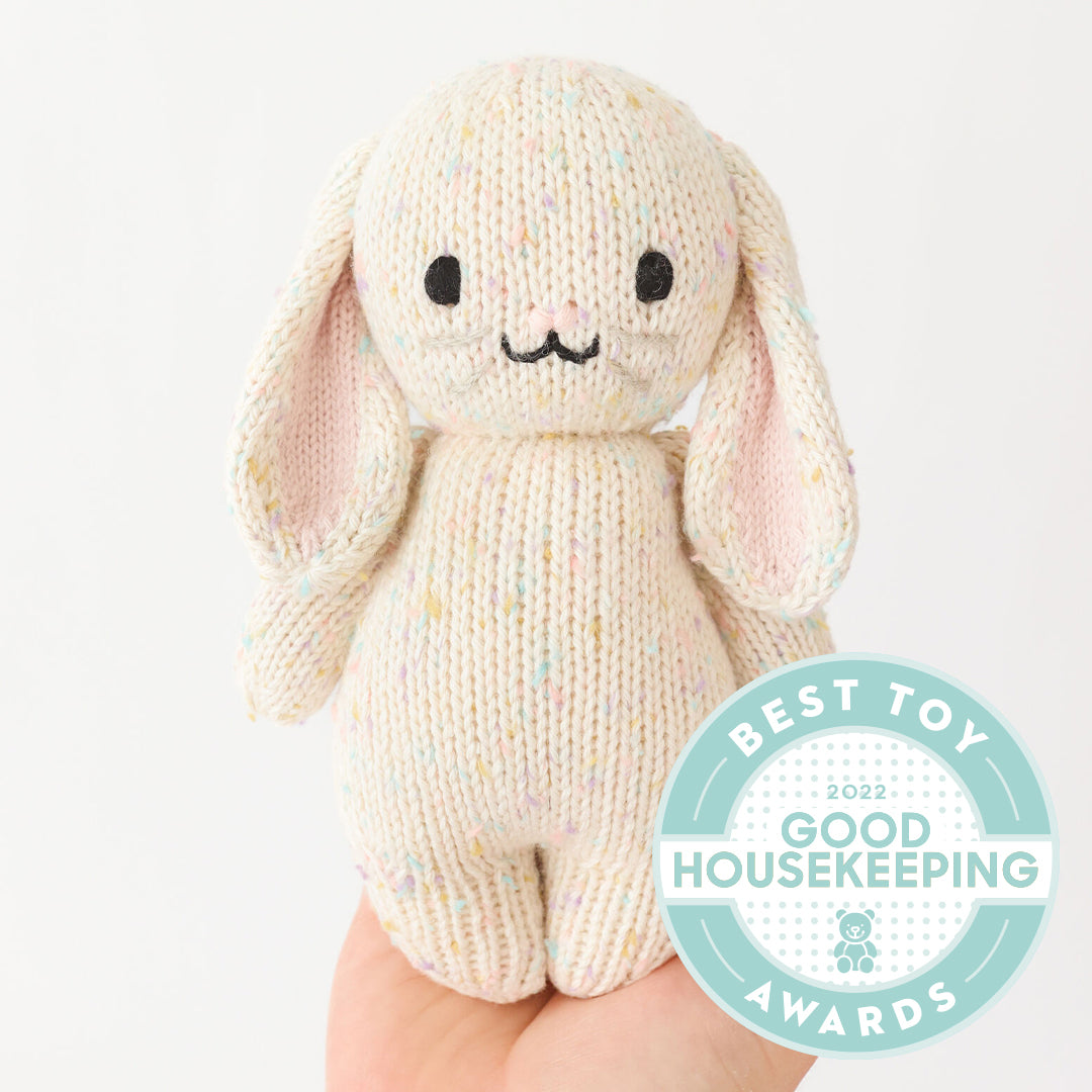 Knitted bunny toy with a 'Best Toy' Good Housekeeping Award badge on a white background
