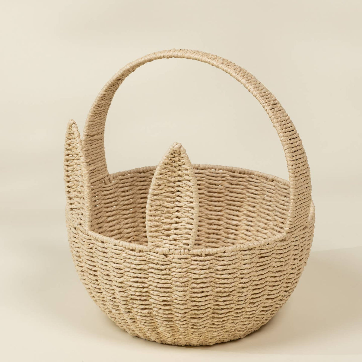 Woven basket with handles on a beige background