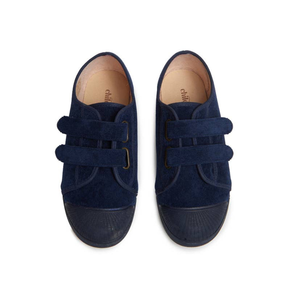 Pair of navy blue children's shoes with velcro straps on a white background