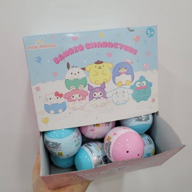 Box of colorful toys with cartoon character packaging on a white background