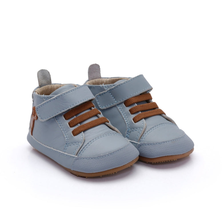 Pair of blue baby shoes with brown accents on a white background