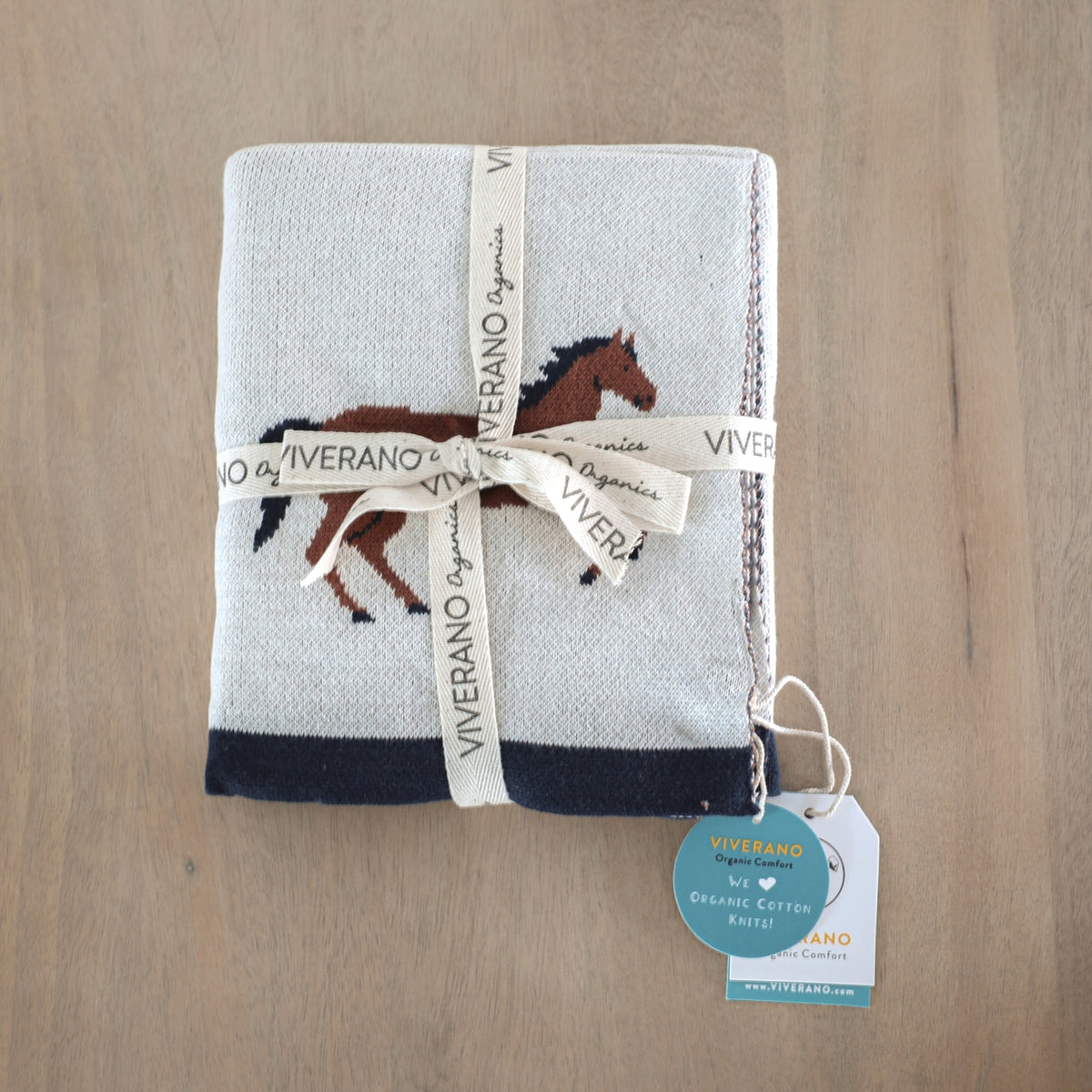 Packaged towel with horse design and Viverano branding on a wooden surface