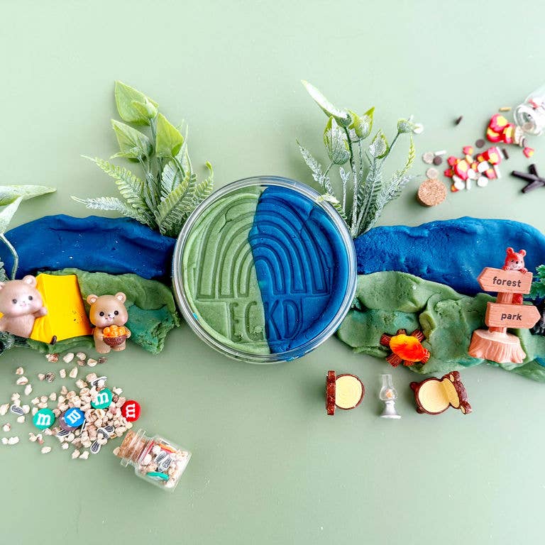 Playdough with green and blue colors, surrounded by small toys and items on a light green background