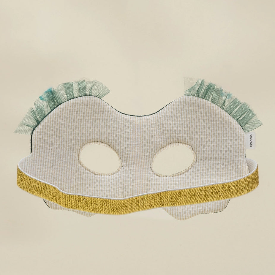 A white and light blue striped fabric mask with a gold glitter trim and ruffled mint green trim at the top, displayed against a plain beige background.