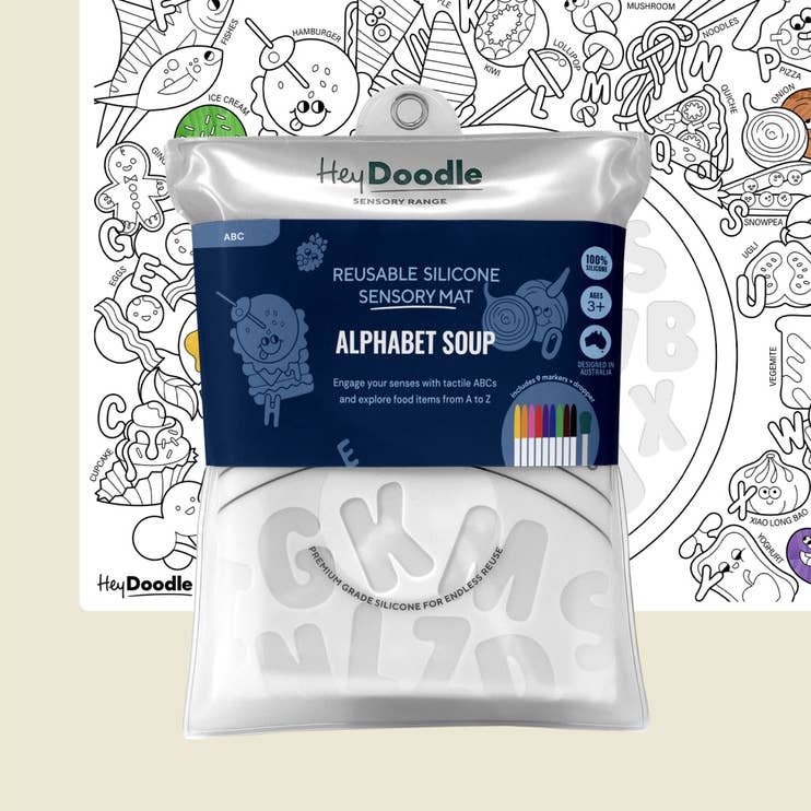 A packaged reusable silicone sensory mat by Hey Doodle, labeled 'Alphabet Soup,' shown in front of a partially visible uncolored coloring page. The package is white with a dark blue front label and includes small color swatches indicating included colors.