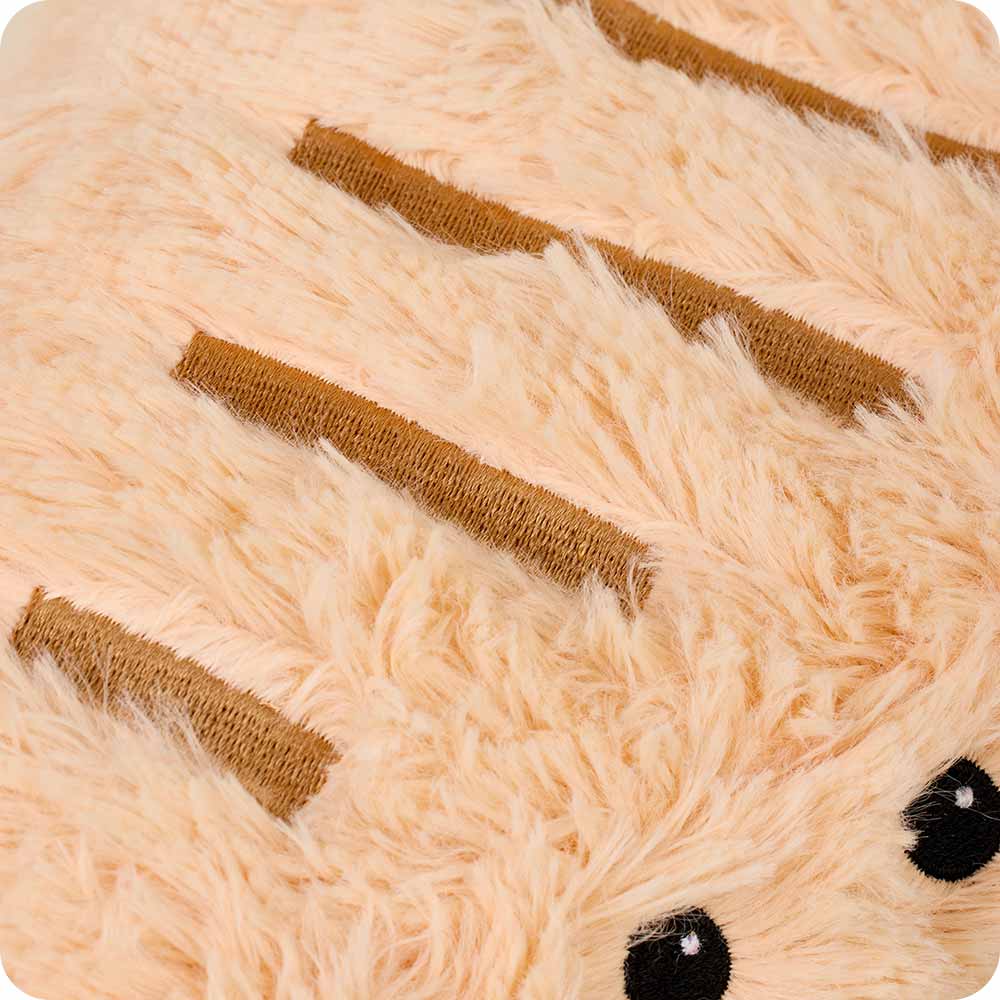Close-up of a plush toy with brown stripes and black eyes on a beige background
