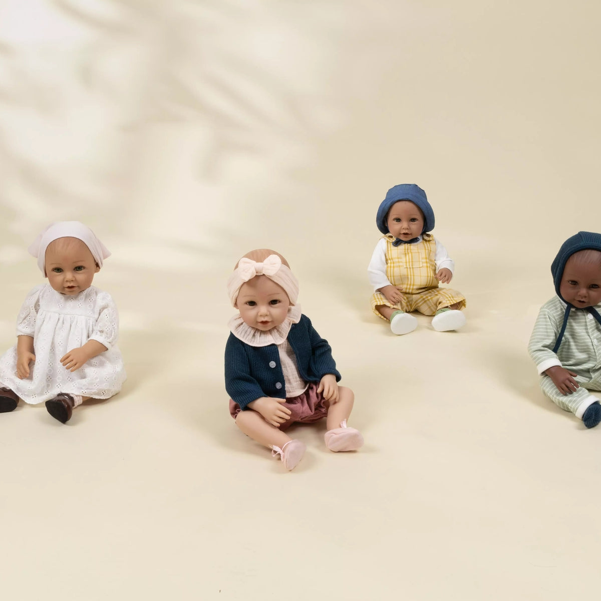Four dolls in different outfits sitting on a beige background