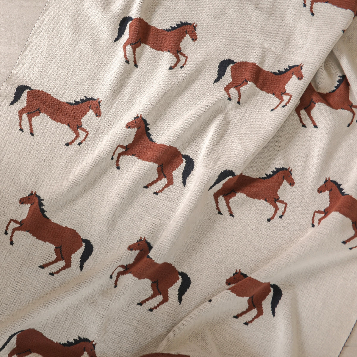 Fabric with brown horse pattern on a beige background
