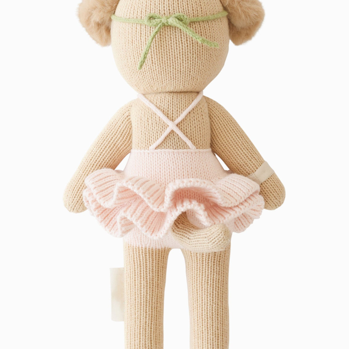 Knitted teddy bear in a pink dress with a white background