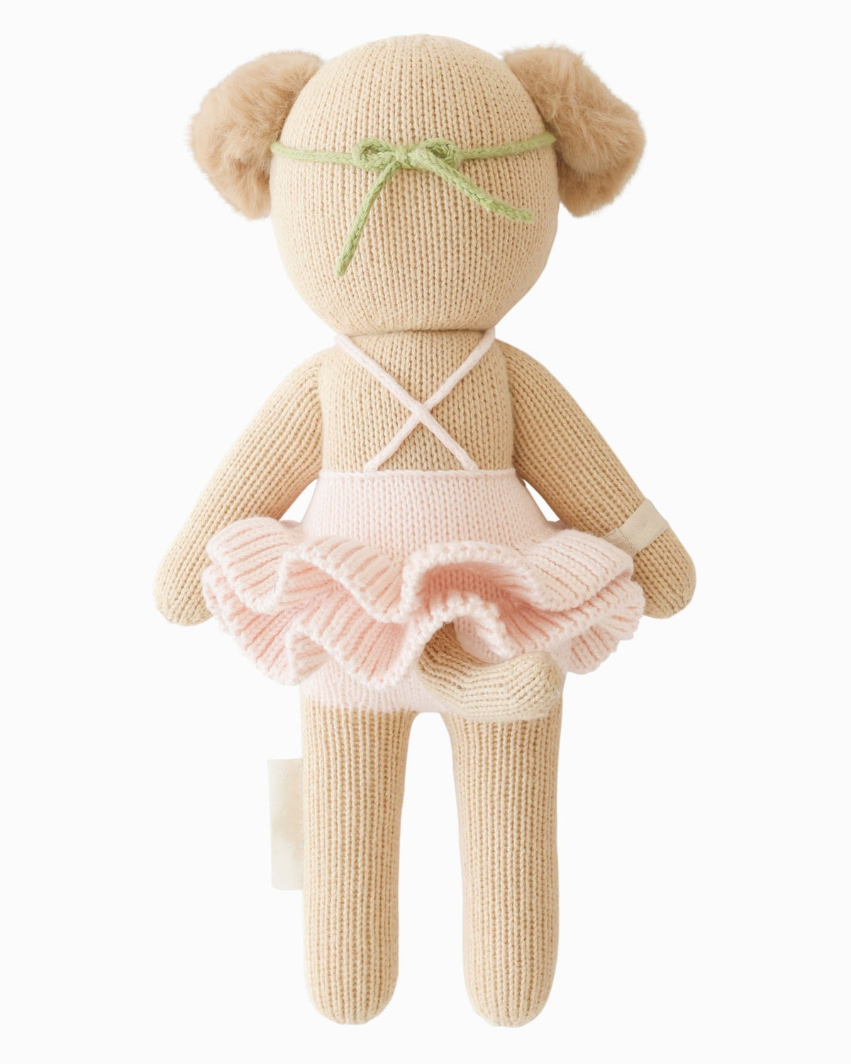 Knitted teddy bear in a pink dress with a white background