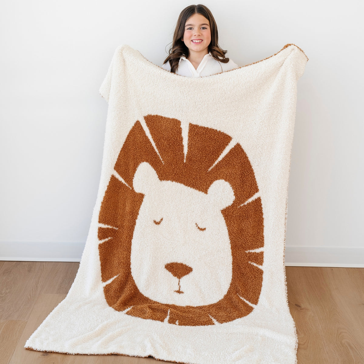 Person holding a lion-themed blanket with a white background