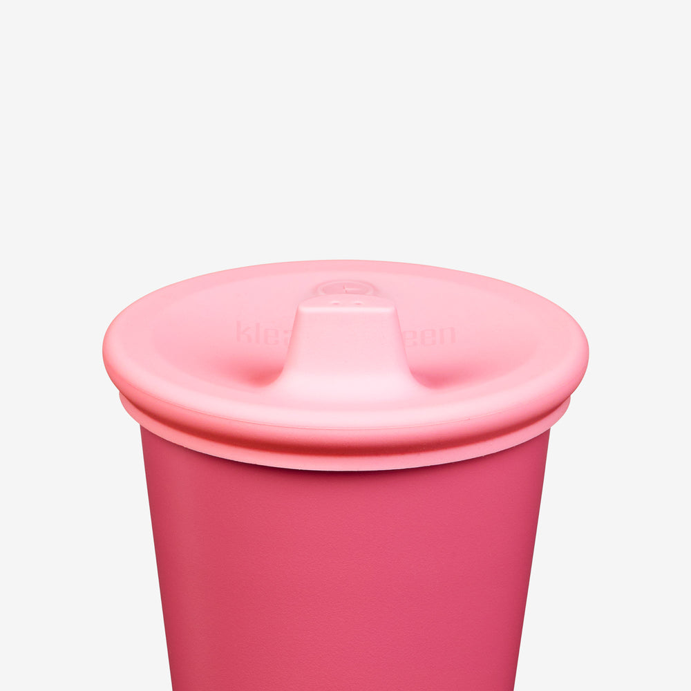 Pink sippy cup with a lid on a light gray background