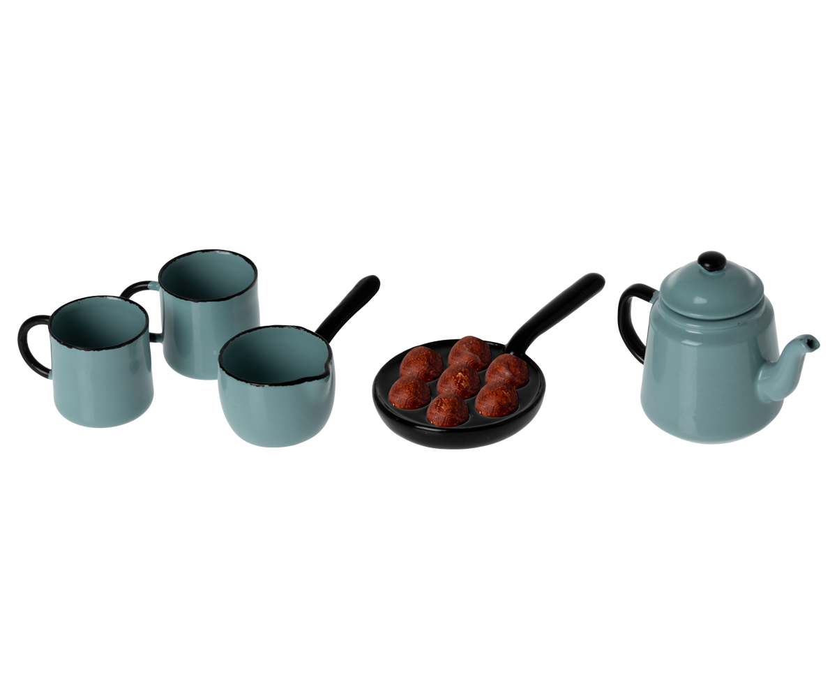 Set of teal cookware including mugs, a pan with food, and a teapot on a white background