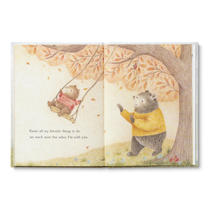Illustrated book open to two pages with bear characters under a tree with autumn leaves.