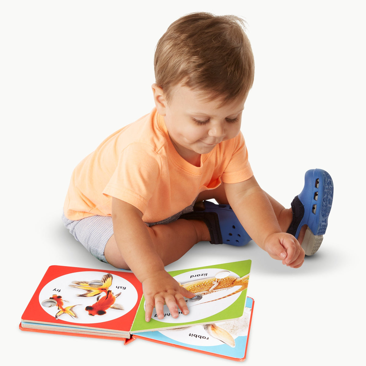 Child sitting on the floor with a colorful book