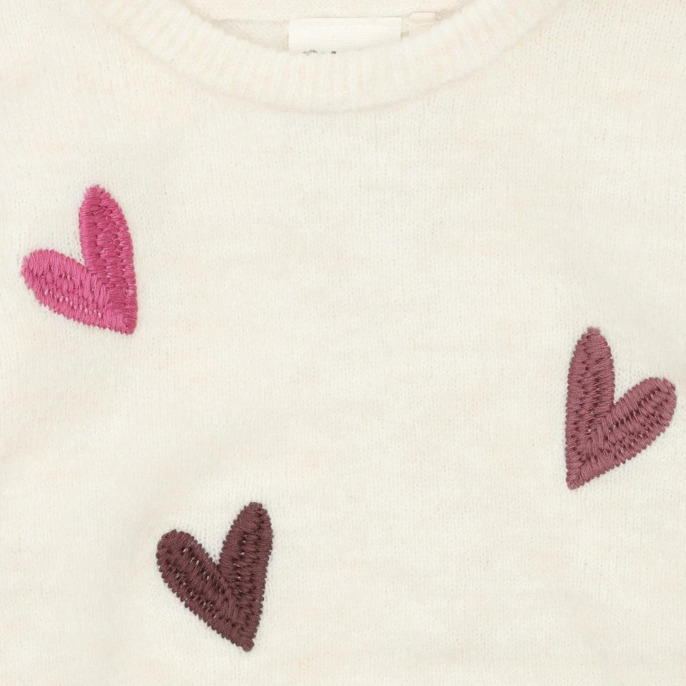 Close-up pattern of small hearts in dark brown, pink, and light gray.