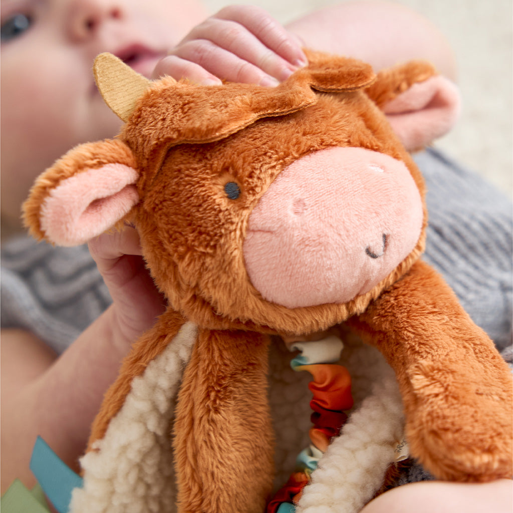 Close-up of a child holding a brown plush toy with a soft texture.