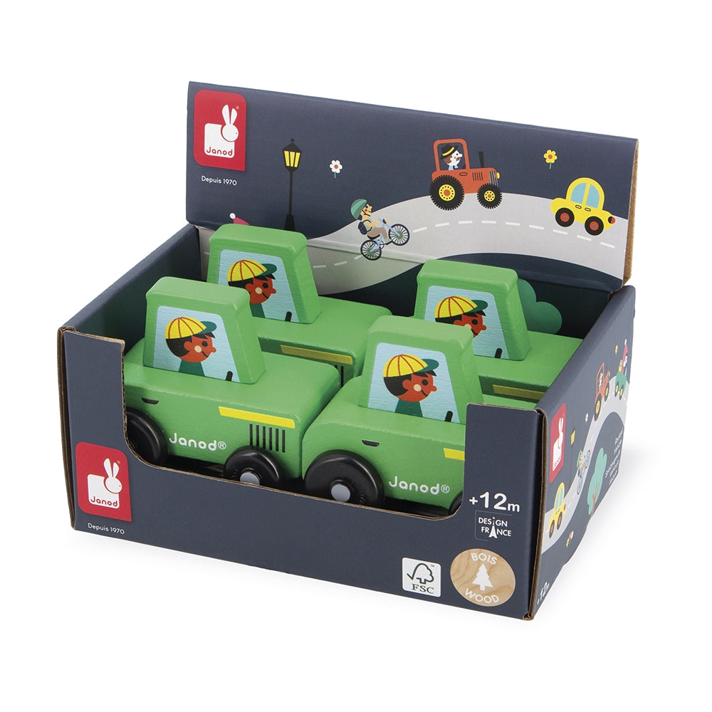 A set of four green wooden toy trucks in their original dark blue retail packaging, featuring the Janod brand logo and illustrations of children on the box.
