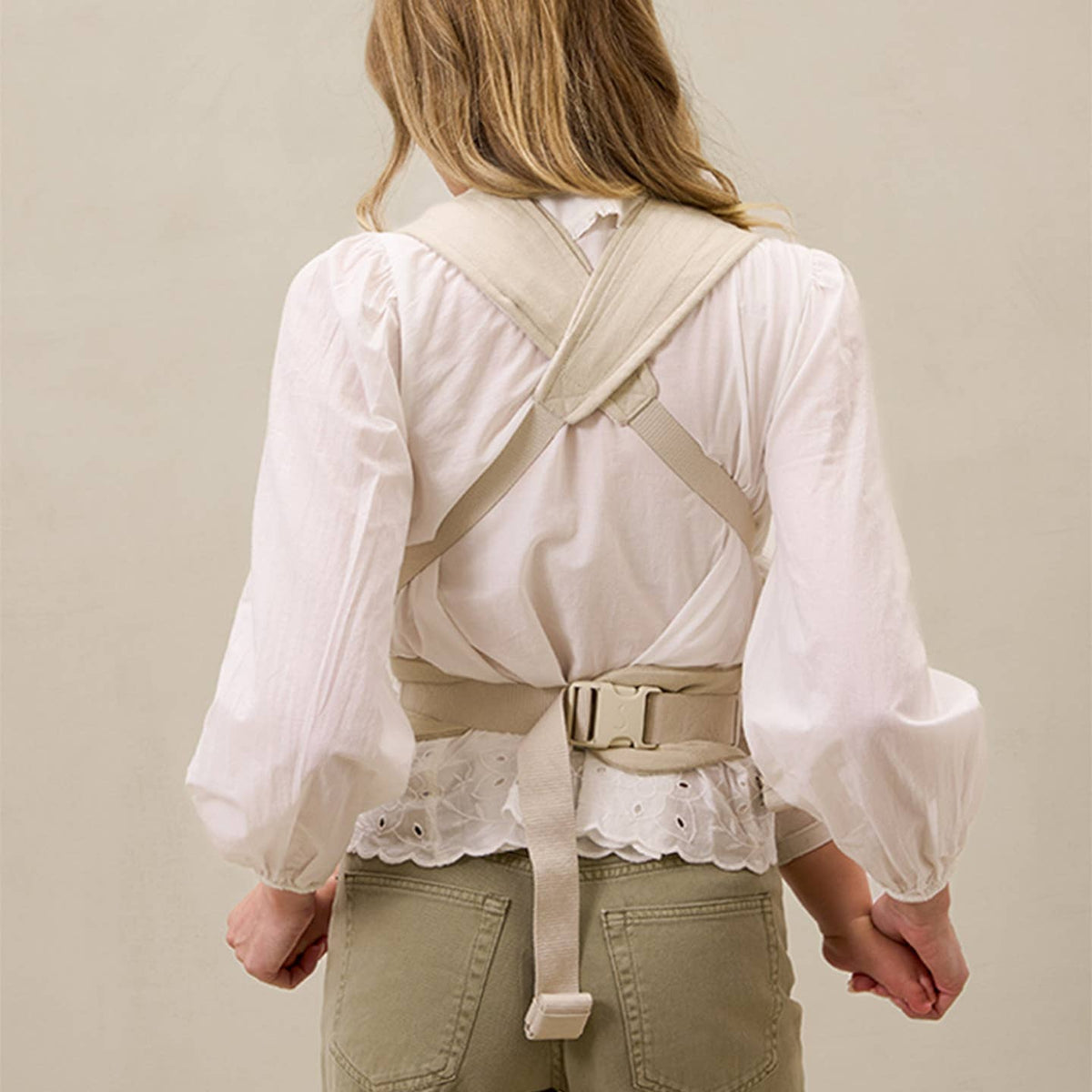 Person wearing a beige back brace against a plain background
