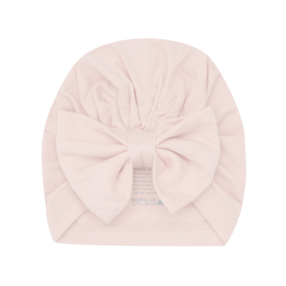 A pale pink baby turban hat with a large bow on the front, shown flat against a white background.