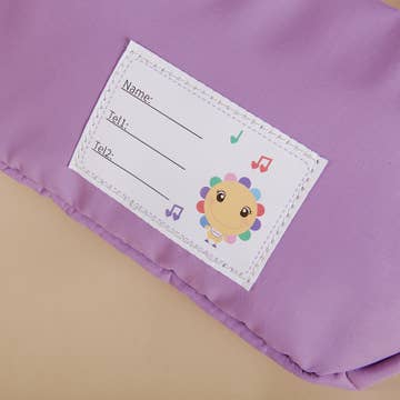 Children's name tag with a cartoon character on a purple background