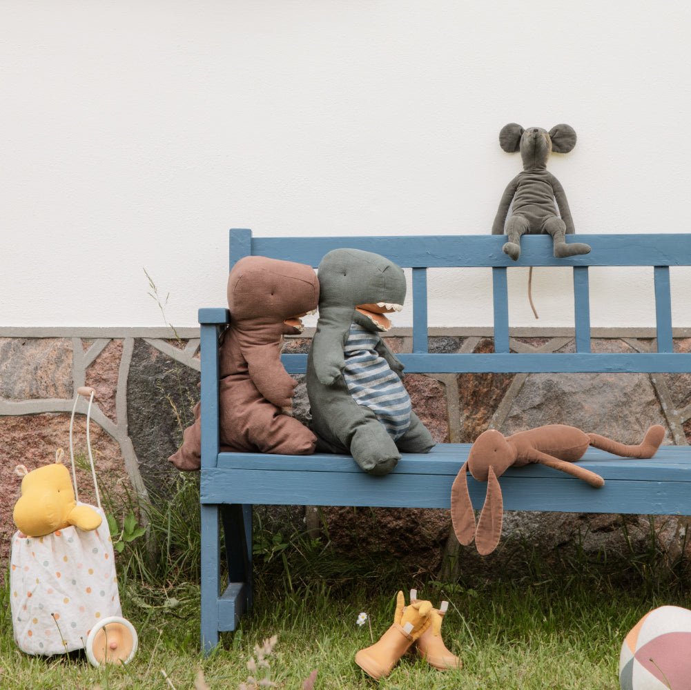 Plush toys on a blue bench outdoors