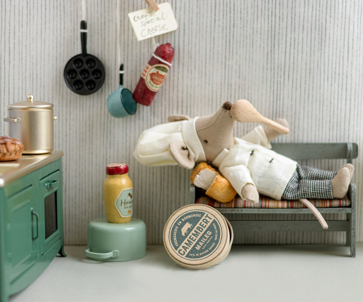 Toy rabbit lying on a bench in a kitchen setting with various items around