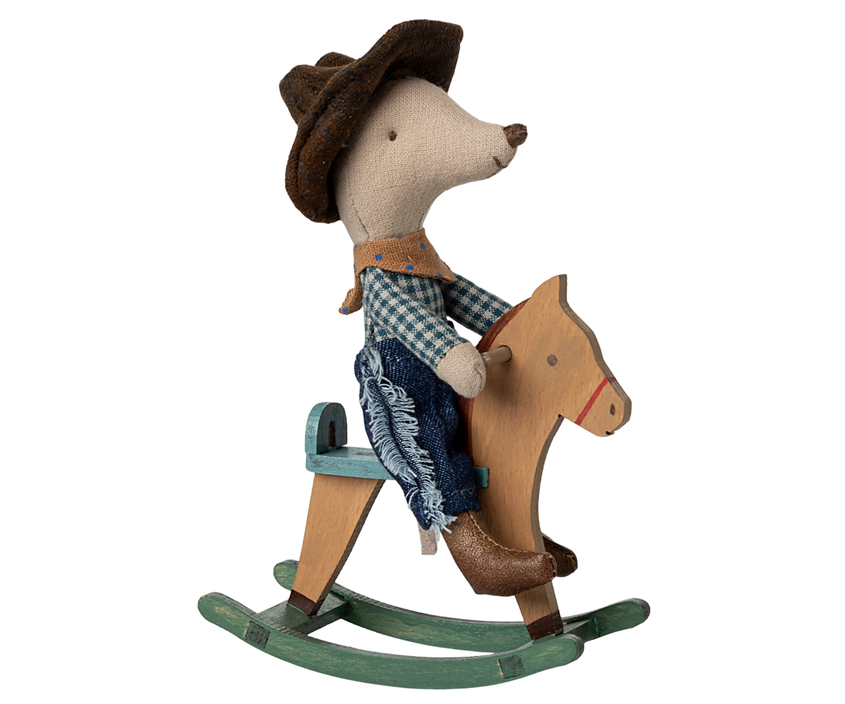 Toy mouse in cowboy outfit riding a wooden horse on a white background