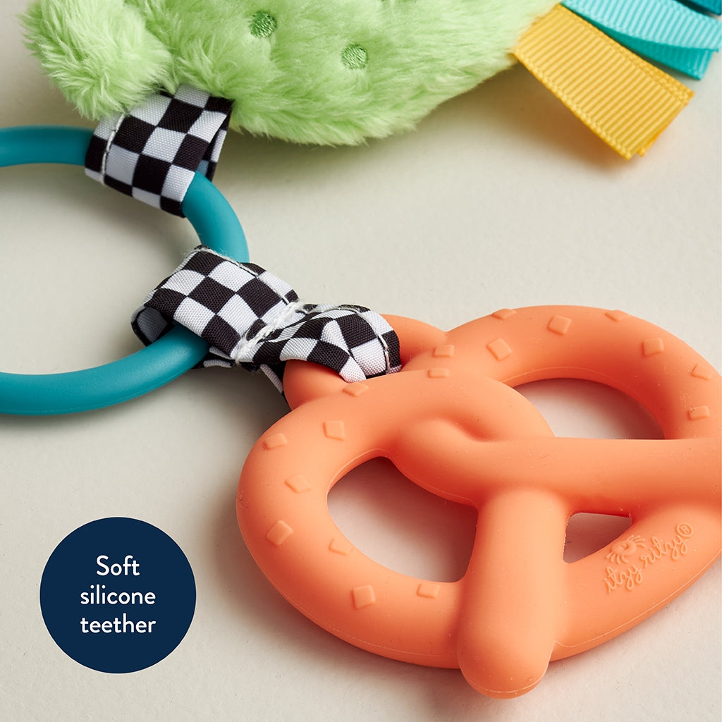Colorful soft silicone teether with checkered band on a light background