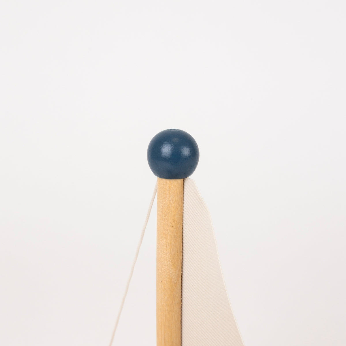 A close-up of top of wooden sailboat, set against a plain white background