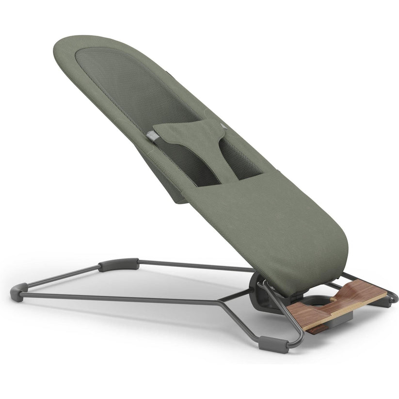 An ergonomic office chair with a padded olive green seat and backrest, supported by a dark gray metal frame with a small wooden footrest.
