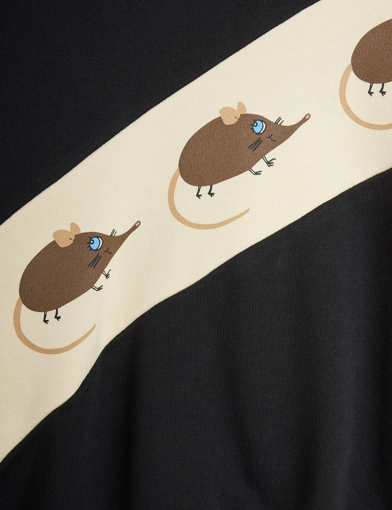 Close-up of a black garment with a wide cream diagonal band featuring cartoon brown mice with blue eyes.