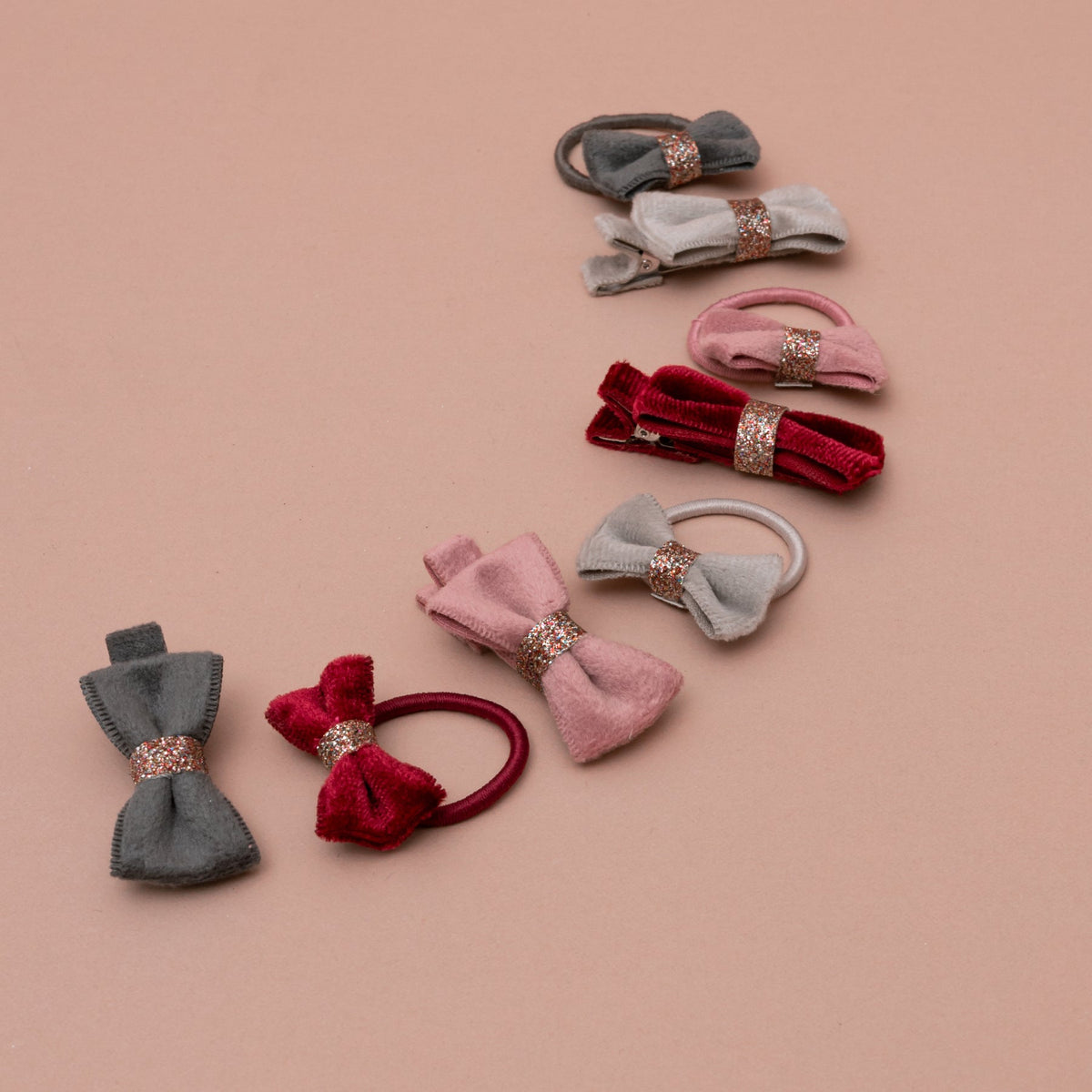 Set of colorful hair bows with decorative elements on a beige background