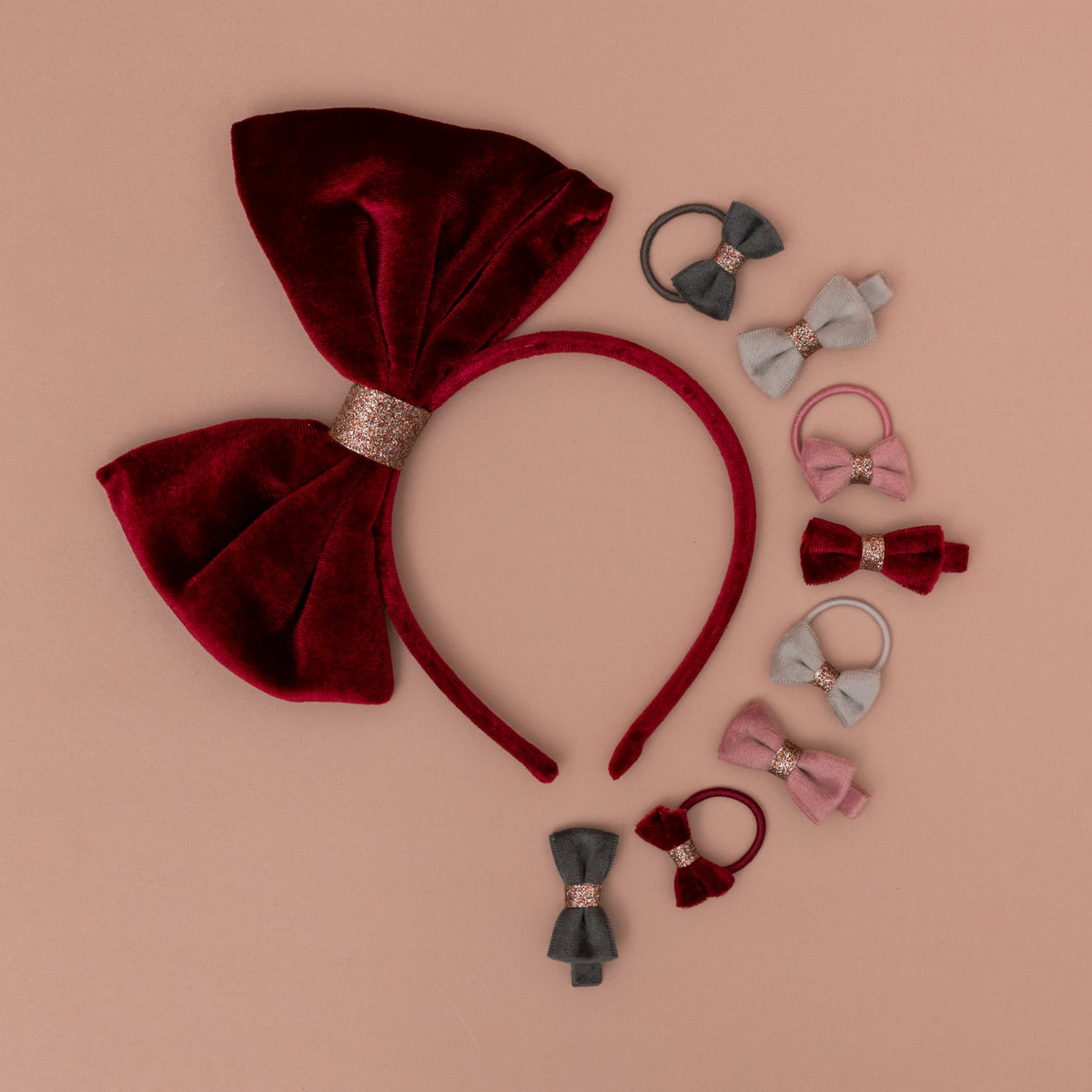 Collection of red and gray hair accessories on a beige background