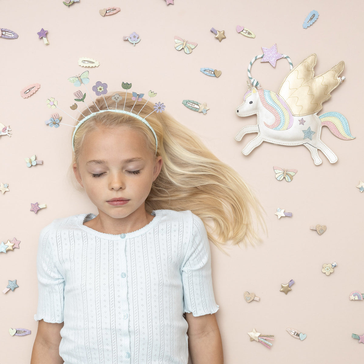 Young girl with butterfly hair clips on a plain background