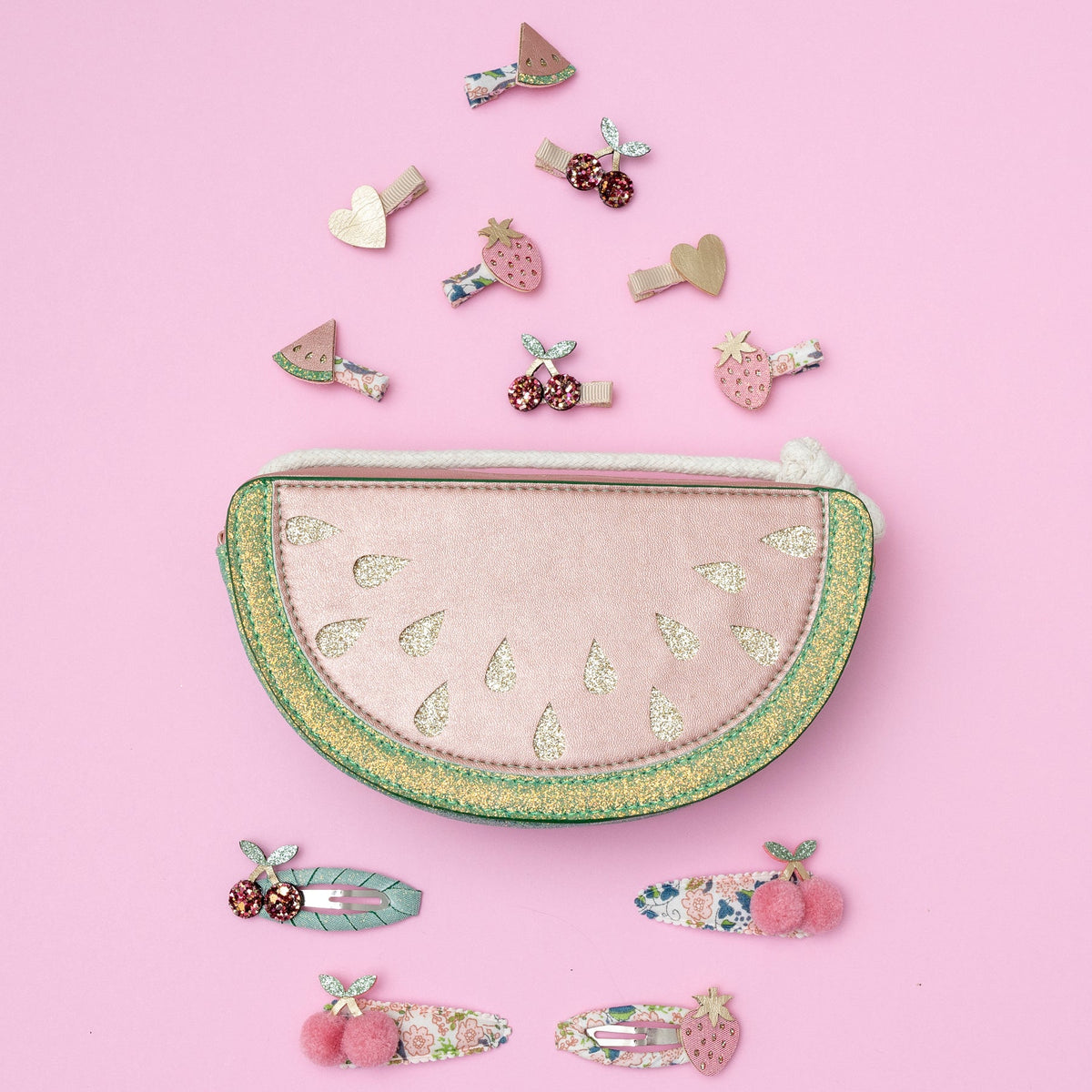 Set of decorative hair clips and a decorative pouch on a pink background