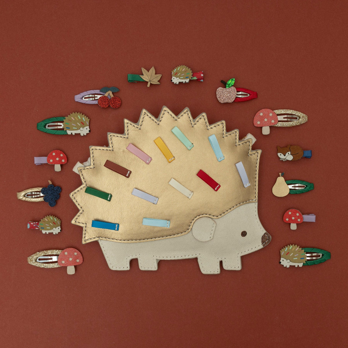 Hedgehog-shaped hair clip with various small hair clips on a brown background