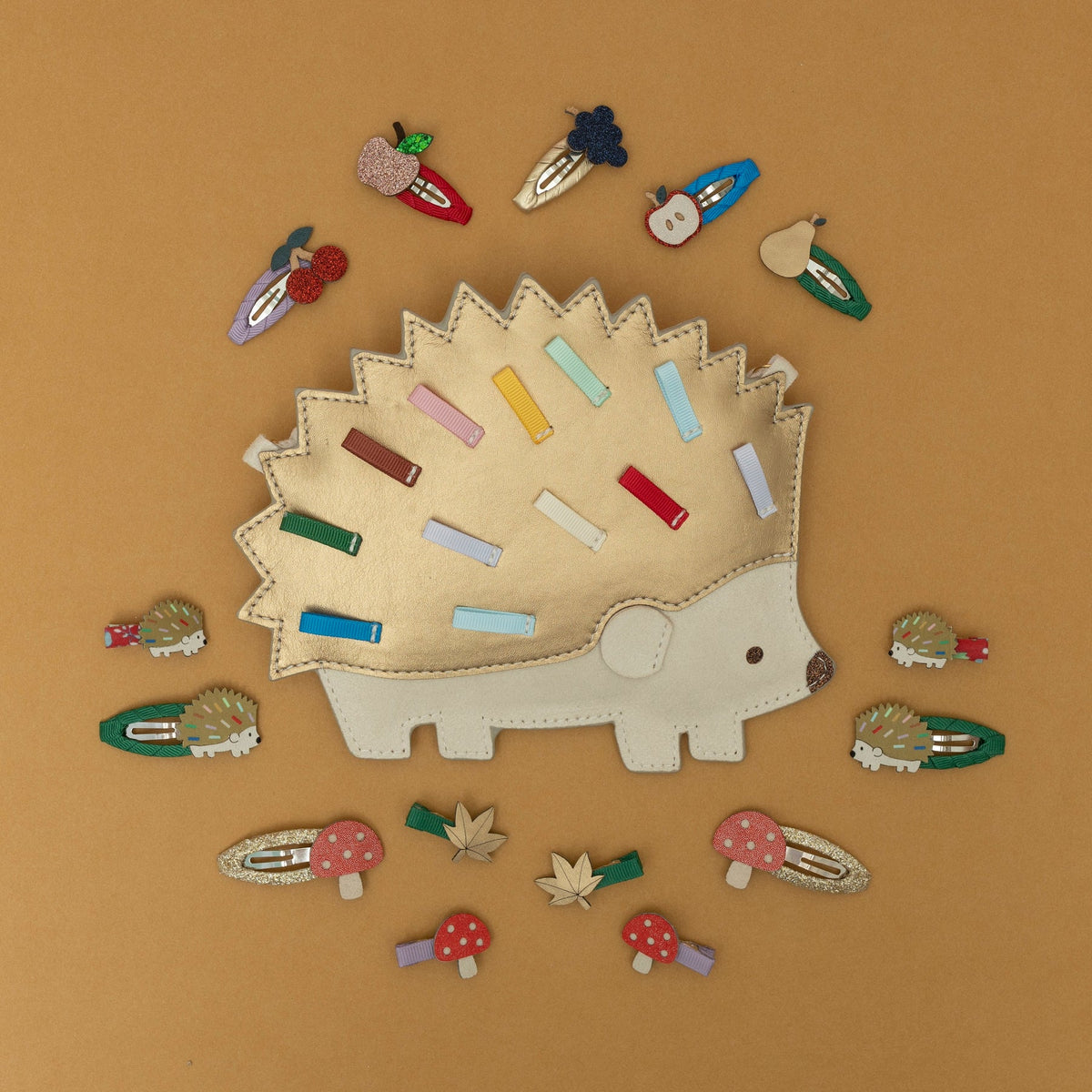Hedgehog-shaped hair clip holder with various colorful hair clips on a brown background