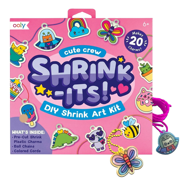 Ooly Cute Crew Shrink-Its! DIY Shrink Art Kit in pink packaging, shown with several colorful shrink-wrapped craft charms attached to cords on a white background.
