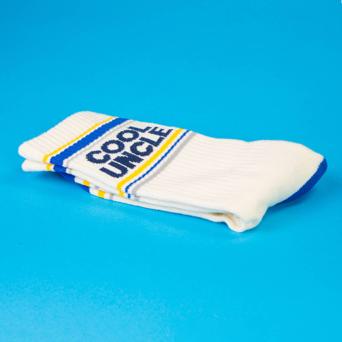 White socks with blue and yellow accents and 'Cool Uncle' text on a blue background