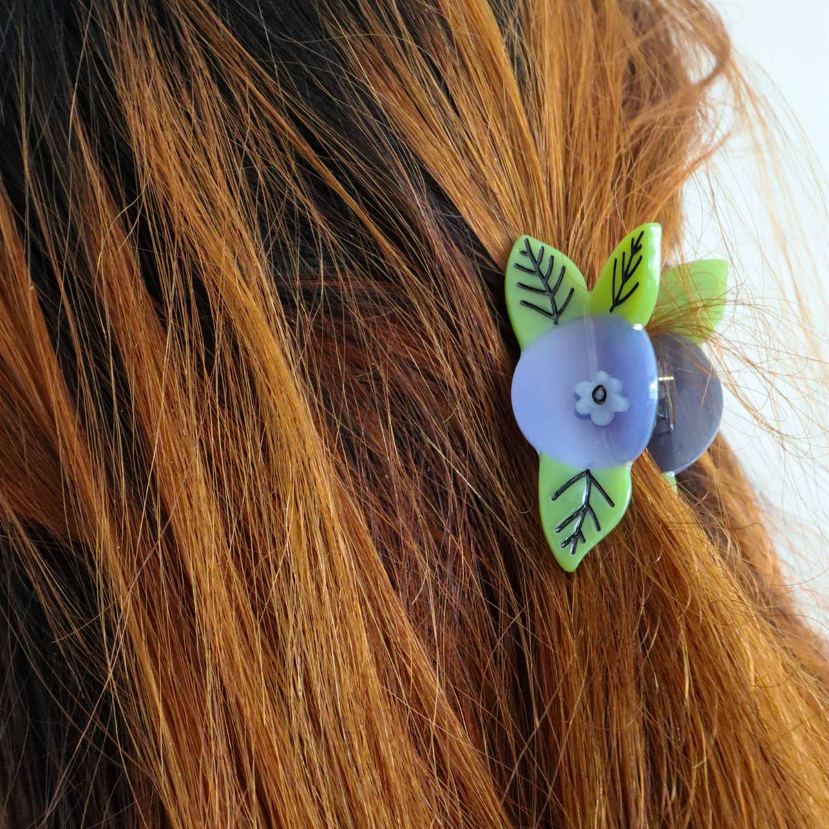 Hair clip with floral design on brown hair