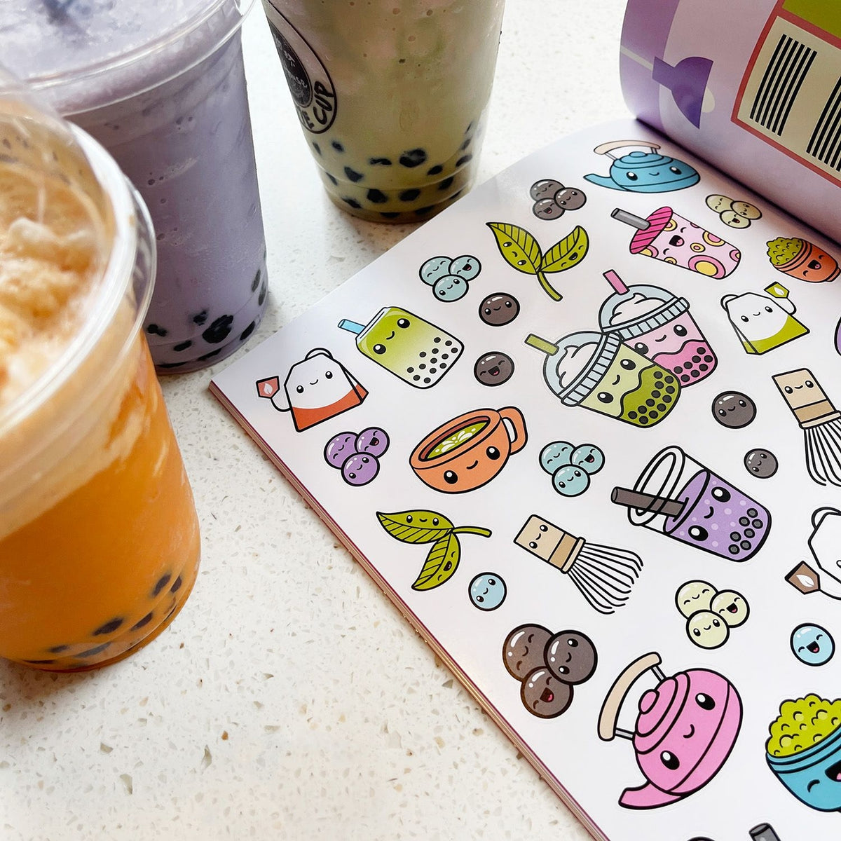 Colorful bubble tea stickers on a white surface with bubble tea cups.
